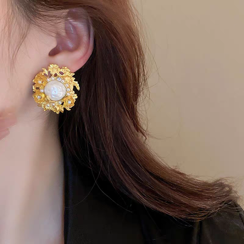 Flowers surround pearl earrings