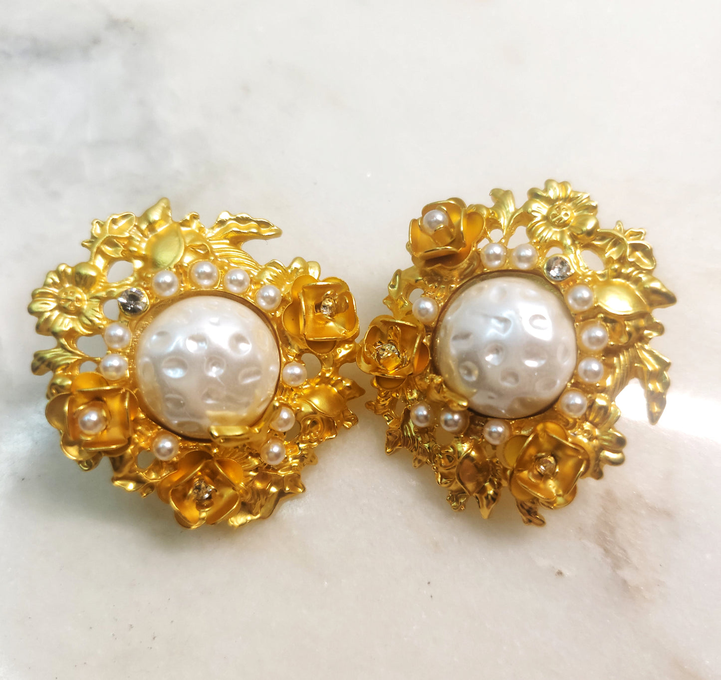 Flowers surround pearl earrings